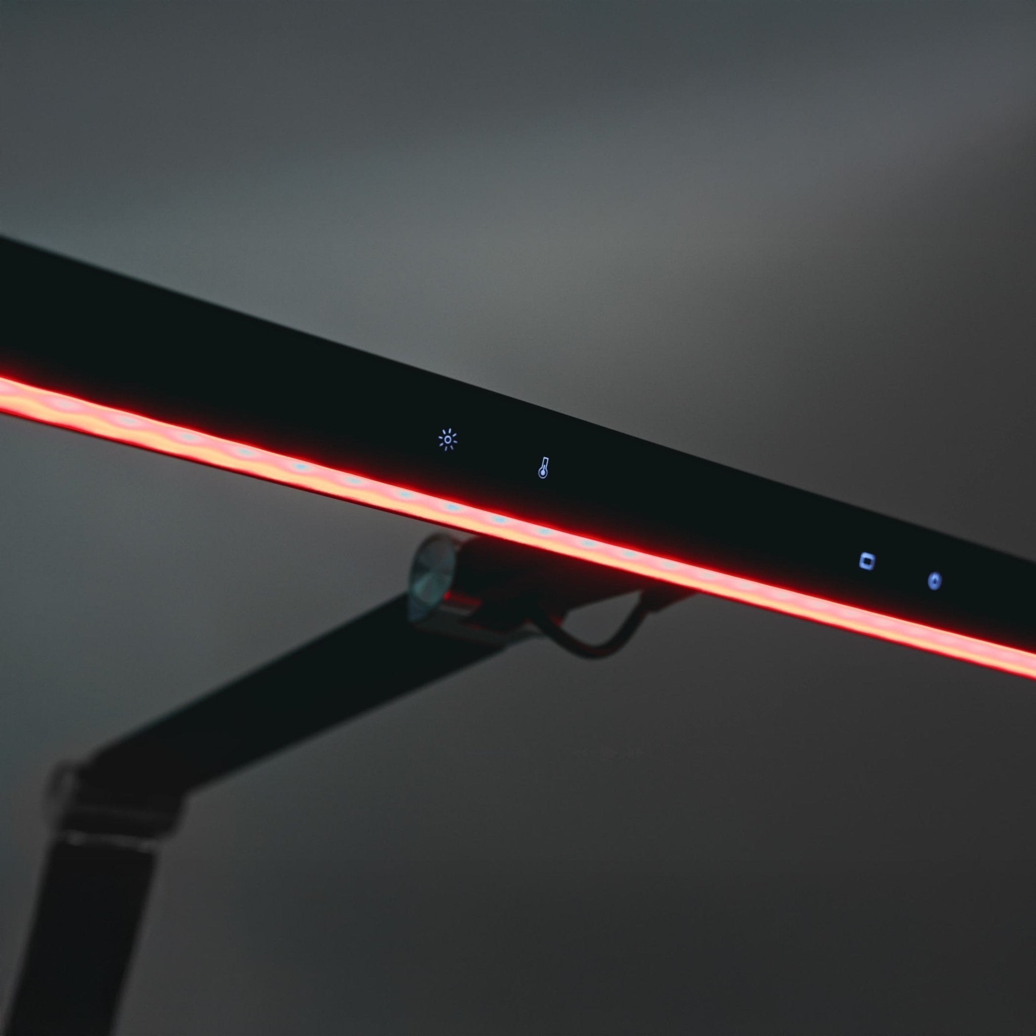 Zbliżenie na lampę biurkową heilys LED z regulacją natężenia, świecącym czerwonym paskiem świetlnym, dotykowym sterowaniem i eleganckim czarnym minimalistycznym designem idealnym do oświetlenia biurowego na neutralnym tle.